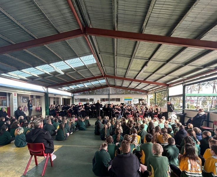 Large gathering of students and band under COLA